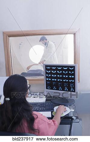 Stock Photo - Hispanic nurse examining scanner results. Fotosearch