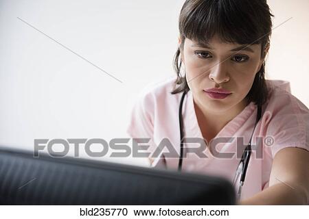 Hispanic nurse using computer View Large Photo Image Stock Image - Hispanic nurse using computer. Fotosearch