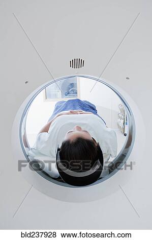 Stock Photo - Hispanic patient in scanner. Fotosearch