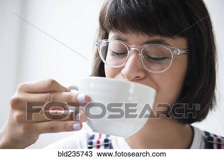 Stock Image - Hispanic woman drinking coffee. Fotosearch