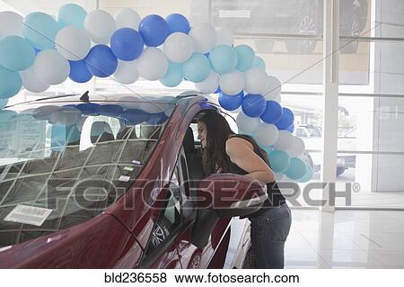 Hispanic woman examining car in dealership showroom View Large Photo Image Stock Photo - Hispanic woman examining car in dealership showroom. Fotosearch