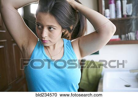 Stock Image - Hispanic woman lifting hair. Fotosearch