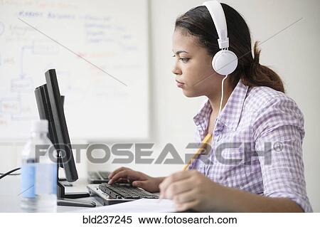 Stock Photography - Hispanic woman typing in computer lab. Fotosearch