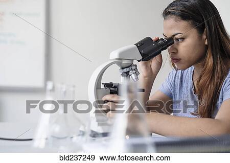 Hispanic woman using microscope View Large Photo Image Stock Photo - Hispanic woman using microscope. Fotosearch