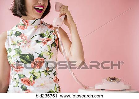 Hispanic woman wearing floral dress holding pink telephone View Large Photo Image Stock Image - Hispanic woman wearing floral dress holding pink telephone. Fotosearch