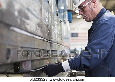 Hispanic worker fabricating metal in factory View Large Photo Image Stock Photo - Hispanic worker fabricating metal in factory. Fotosearch