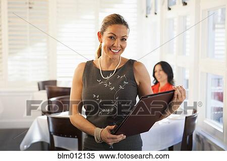 Hostess holding menu in restaurant View Large Photo Image Stock Photography - Hostess holding menu in restaurant. Fotosearch