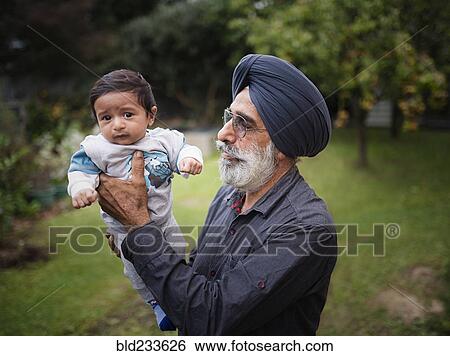 Stock Photograph - Indian grandfather holding baby grandson. Fotosearch