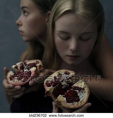 Intertwined Caucasian girls holding sliced pomegranate View Large Photo Image Stock Image - Intertwined Caucasian girls holding sliced pomegranate. Fotosearch