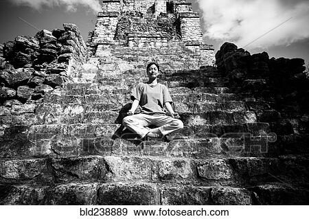 Stock Photo - Japanese woman meditating on staircase to temple. Fotosearch