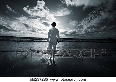 Stock Photography - Japanese woman walking on beach. Fotosearch