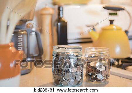 Jars of coins on kitchen counter View Large Photo Image Stock Image - Jars of coins on kitchen counter. Fotosearch