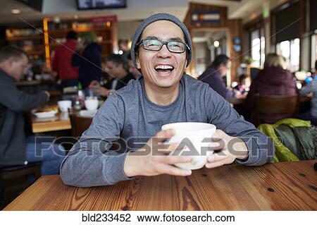 Laughing Asian man in coffee shop View Large Photo Image Stock Image - Laughing Asian man in coffee shop. Fotosearch