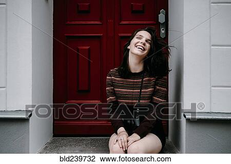Laughing Caucasian woman sitting in doorway View Large Photo Image Stock Image - Laughing Caucasian woman sitting in doorway. Fotosearch