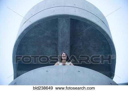 Low angle view of businesswoman leaning on balcony View Large Photo Image Stock Photo - Low angle view of businesswoman leaning on balcony. Fotosearch
