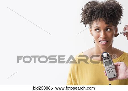 Stock Photography - Makeup artist using makeup brush on woman. Fotosearch