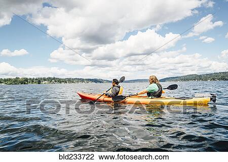 Man and woman paddling kayak View Large Photo Image Stock Image - Man and woman paddling kayak. Fotosearch