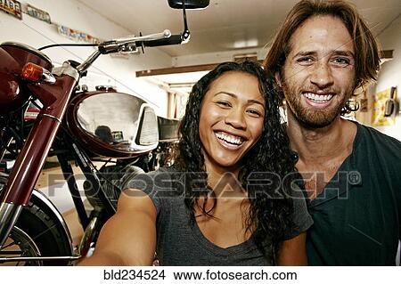 Man and woman posing for selfie with motorcycle in garage View Large Photo Image Picture - Man and woman posing for selfie with motorcycle in garage. Fotosearch