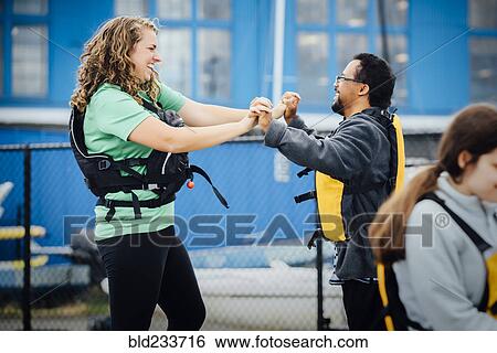 Stock Photograph - Man and woman wearing life-jackets holding hands. Fotosearch