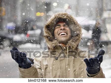 Stock Photo - Man enjoying snow in city. Fotosearch