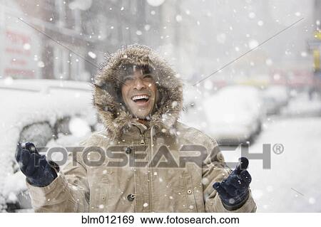 Stock Photo - Man enjoying snow in city. Fotosearch