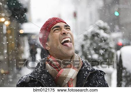 Stock Photography - Man enjoying snow in city. Fotosearch