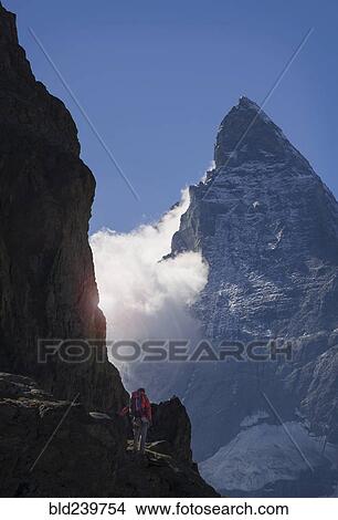 Picture - Man hiking in mountain near clouds. Fotosearch