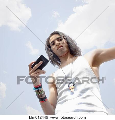 Man holding cell phone outdoors View Large Photo Image Stock Photography - Man holding cell phone outdoors. Fotosearch