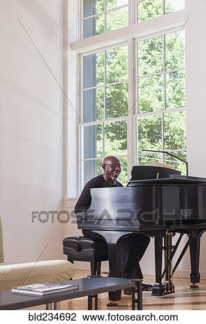 Man playing piano near window View Large Photo Image Stock Image - Man playing piano near window. Fotosearch