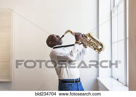 Man playing saxophone window View Large Photo Image Picture - Man playing saxophone window. Fotosearch