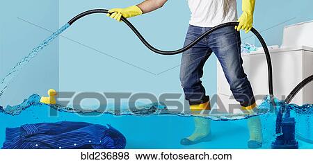 Man pumping water in flooding laundry room View Large Photo Image Stock Photo - Man pumping water in flooding laundry room. Fotosearch