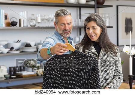 Man showing sweater to woman in store View Large Photo Image Picture - Man showing sweater to woman in store. Fotosearch