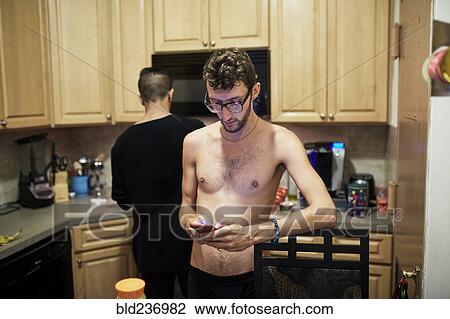 Man with bare chest texting on cell phone in kitchen View Large Photo Image Stock Image - Man with bare chest texting on cell phone in kitchen. Fotosearch