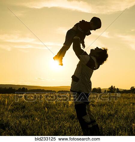 Mari man lifting son in field at sunset View Large Photo Image Stock Photography - Mari man lifting son in field at sunset. Fotosearch