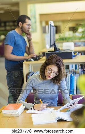 Mixed Race boy and girl studying in library View Large Photo Image Stock Photo - Mixed Race boy and girl studying in library. Fotosearch