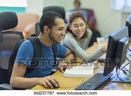 Mixed Race boy and girl using computer in library View Large Photo Image Stock Photo - Mixed Race boy and girl using computer in library. Fotosearch