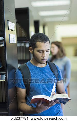 Mixed Race boy reading book in library View Large Photo Image Stock Image - Mixed Race boy reading book in library. Fotosearch