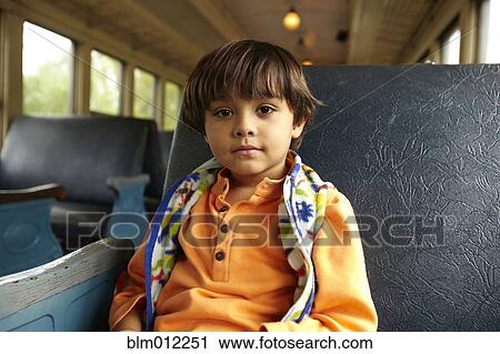 Stock Image - Mixed race boy riding on train. Fotosearch