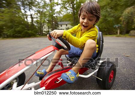 Mixed race boy riding toy car View Large Photo Image Stock Image - Mixed race boy riding toy car. Fotosearch