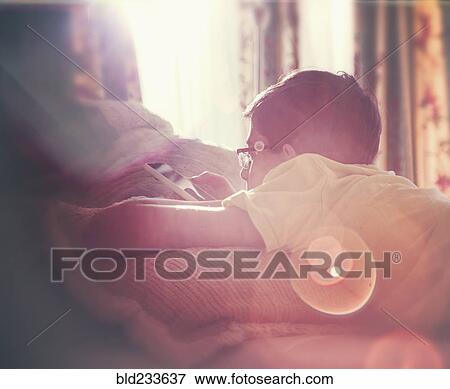 Mixed Race boy texting on cell phone near window View Large Photo Image Stock Photo - Mixed Race boy texting on cell phone near window. Fotosearch