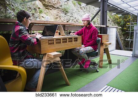 Mixed Race brother and sister using laptops on veranda View Large Photo Image Stock Image - Mixed Race brother and sister using laptops on veranda. Fotosearch