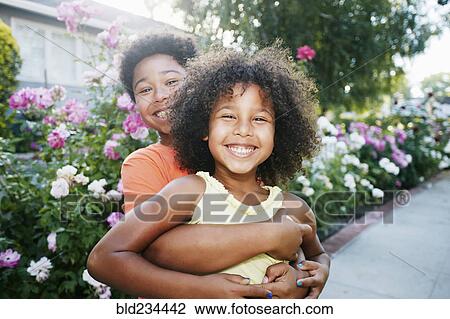 Mixed Race brother hugging sister outdoors View Large Photo Image Stock Image - Mixed Race brother hugging sister outdoors. Fotosearch