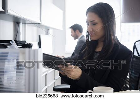 Mixed Race businesswoman using digital tablet in office View Large Photo Image Stock Photo - Mixed Race businesswoman using digital tablet in office. Fotosearch