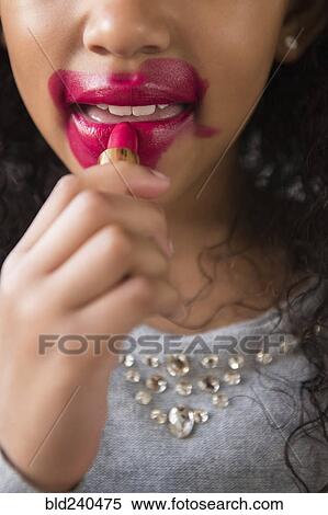 Mixed Race girl applying messy lipstick View Large Photo Image Stock Photography - Mixed Race girl applying messy lipstick. Fotosearch