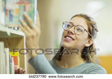 Mixed Race girl choosing book in library View Large Photo Image Stock Image - Mixed Race girl choosing book in library. Fotosearch