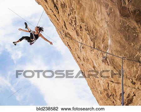 Mixed Race girl hanging from rope while rock climbing View Large Photo Image Stock Image - Mixed Race girl hanging from rope while rock climbing. Fotosearch