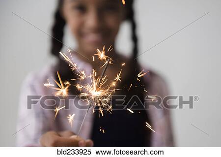 Stock Photography - Mixed Race girl holding sparkler. Fotosearch