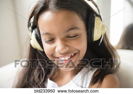 Mixed Race girl listening to headphones View Large Photo Image Stock Image - Mixed Race girl listening to headphones. Fotosearch