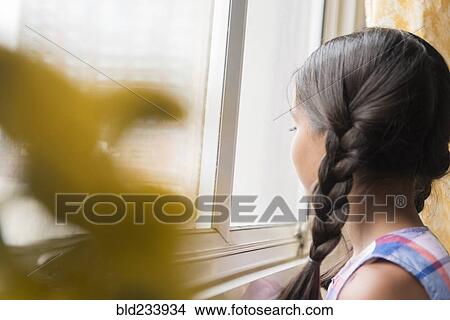 Picture - Mixed Race girl looking out window. Fotosearch