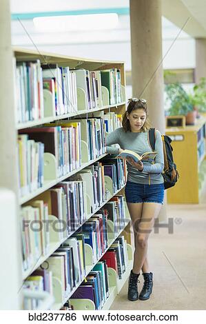 Mixed Race girl reading book in library View Large Photo Image Stock Photograph - Mixed Race girl reading book in library. Fotosearch